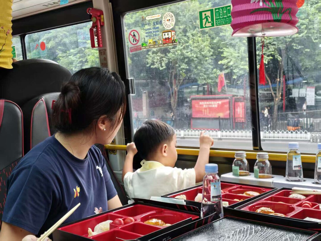 乘客在车上用餐，同时观看沿途街景